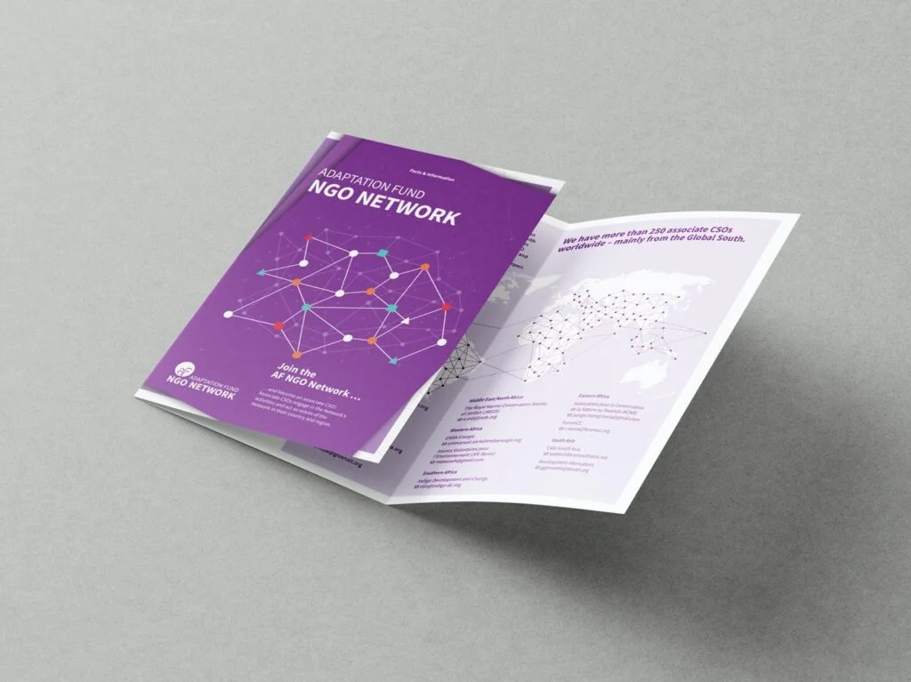 Auf dem Bild ist ein aufgeklappter, sechsseitiger Flyer mit violettem Titelblatt und Netzwerkgrafik zum Thema Adaptation Fund NGO Network auf grauem Untergrund zu sehen.