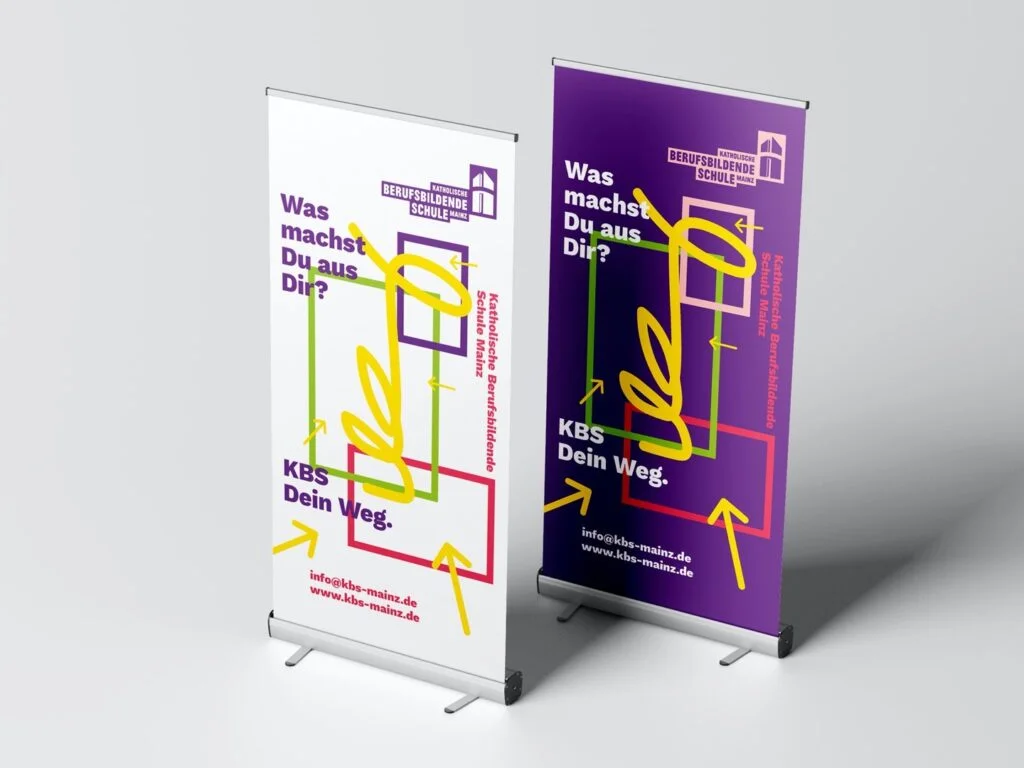 Zwei aufgestellte Roll-up-Banner der Katholischen Berufsbildenden Schule Mainz mit dem Slogan Was machst Du aus Dir und Kontaktinformationen.