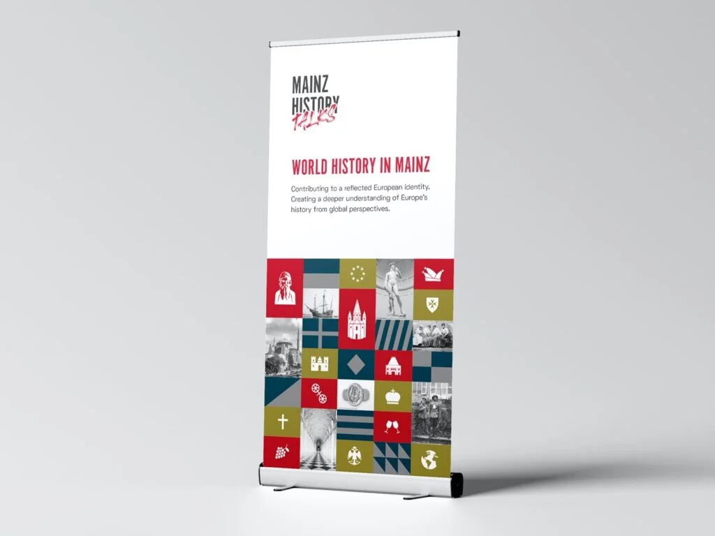 Auf einem Roll-up steht der Text Mainz History Talks und World History in Mainz mit verschiedenen historischen Symbolen und Bildern in farbigen Quadraten.