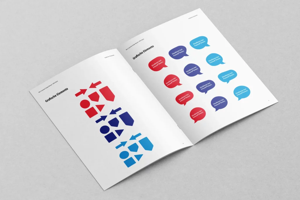 Geöffnetes Heft mit grafischen Elementen in Rot, Blau und Hellblau, darunter Pfeile, geometrische Formen und Sprechblasen mit Text.